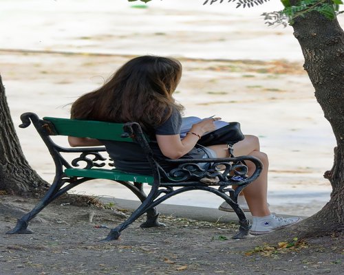 A person taking a relaxed break on a city bench